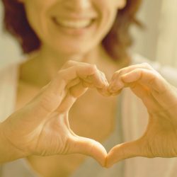 A woman making a heart with her hands
